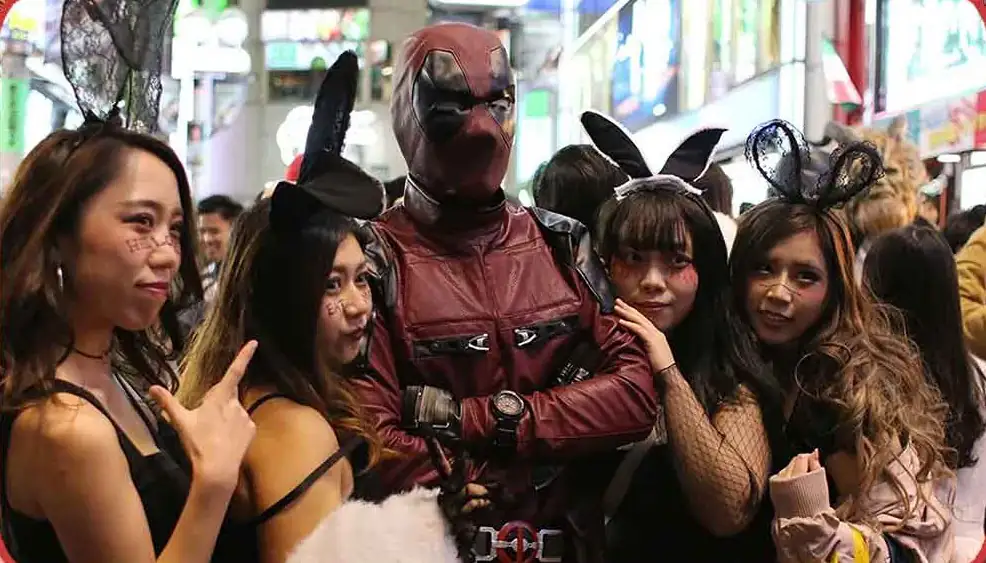 At Shibuya on Halloween in Japan: man dressed as Deadpool with 4 girls dressed as black bunny