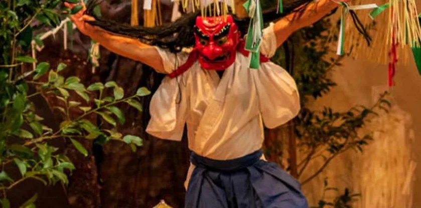 A man wearing a red Japanese mask, white kimono and blue hakama